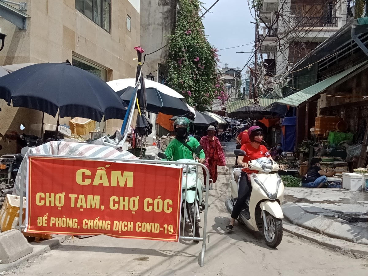 Biển báo, rào chắn Cấm họp chợ được đặt tại khu vực ngõ 104, Nguyễn An Ninh (quận Hoàng Mai) tuy nhiên không có bóng dáng của lực lượng chức năng nên chợ tạm vẫn hoạt động.