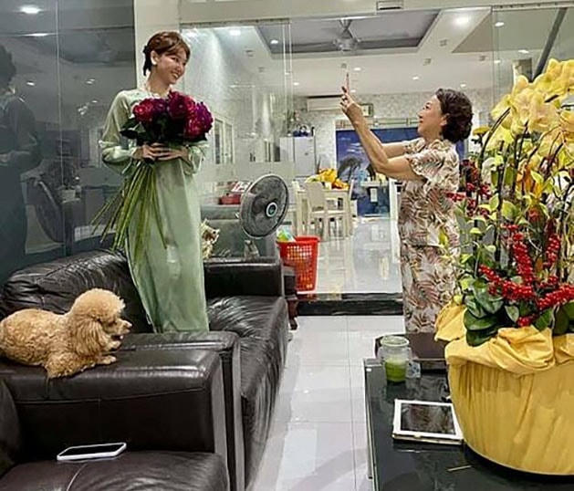Mẹ Trấn Thành nhiệt tình làm thợ nhiếp ảnh cho con dâu Hari Won khi cô qua nhà chúc Tết.  