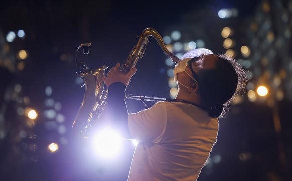 Cuối tháng 7 vừa qua, nghệ sĩ saxophone Trần Mạnh Tuấn gây xúc động mạnh khi biểu diễn nhạc phẩm "Quê hương" tại một bệnh viện dã chiến ở TP HCM - Ảnh: Ngô Trần Hải An.