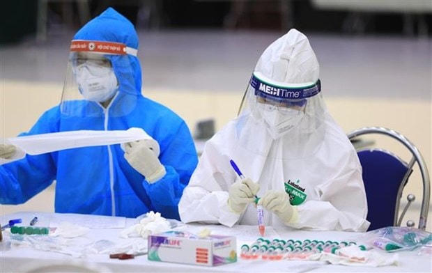 Nhân viên y tế của quận Cầu Giấy, Hà Nội đánh số và tên tuổi các mẫu xét nghiệm PCR của người dân từ Đà Nẵng trở về. Ảnh: TTXVN.
