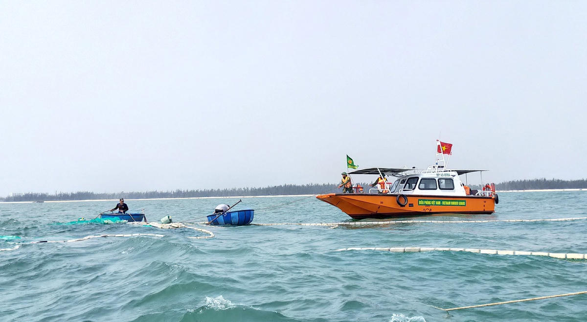 Lực lượng Đồn biên phòng Cửa Đại nỗ lực trục vớt tàu cá bị chìm.