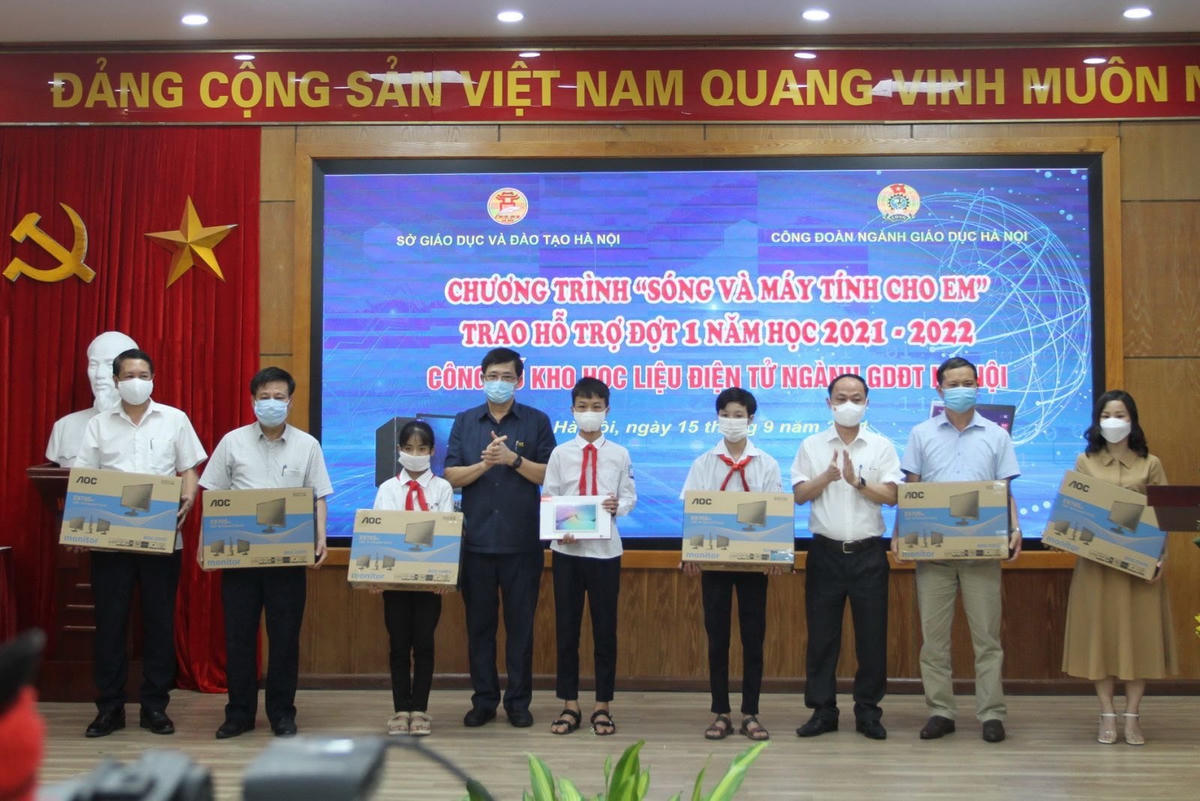 Lãnh đạo Sở GDĐT Hà Nội trao máy tính cho đại diện học sinh khó khăn. 