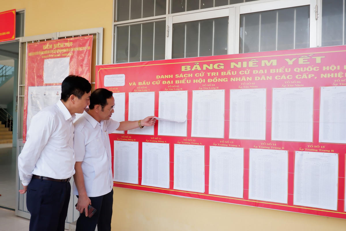 Thành viên đoàn công tác xem danh sách niêm yết trước UBND xã Tân Thới, huyện Phong Điền