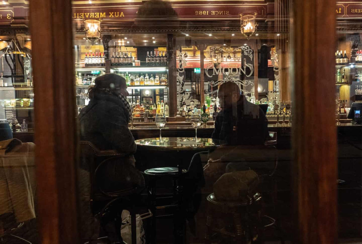 Mọi người tụ tập ăn uống sau giờ làm việc tại văn phòng ở thủ đô London. Ảnh: The Guardian.