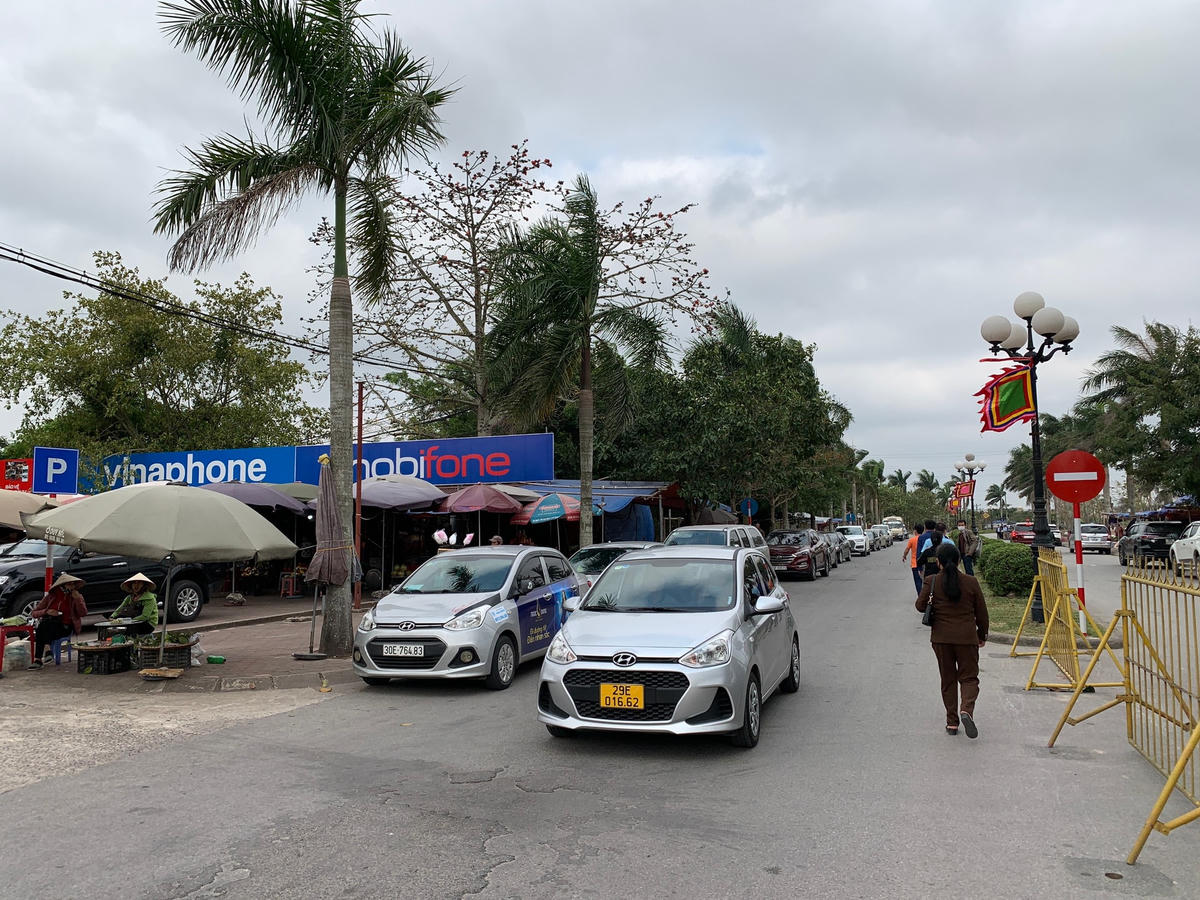 Đường Trần Thừa chạy qua cửa đền vắng người nên một số ô tô được đỗ dọc đường.