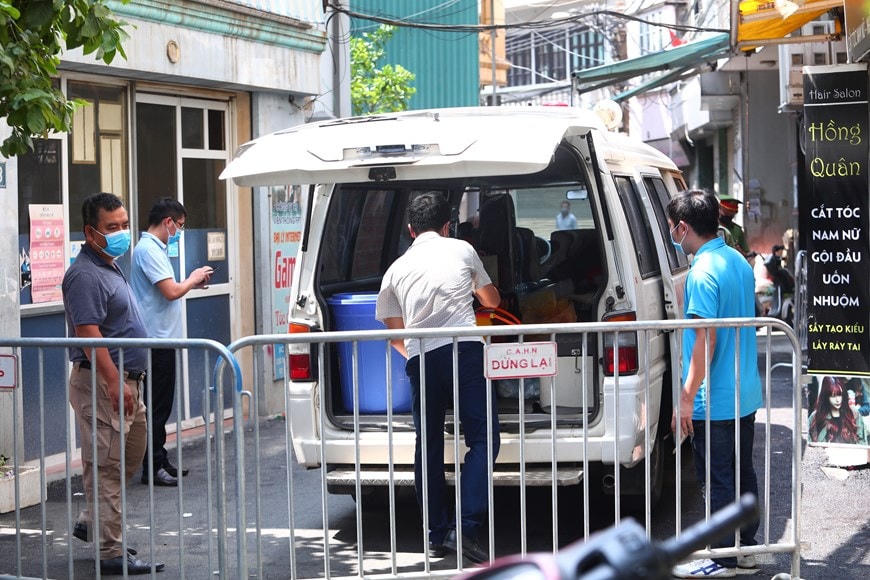 Lực lượng chức năng phong tỏa khu vực ngõ 230/26 Mễ Trì Thượng, nơi có trường hợp nghi nhiễm Covid-19 đang sinh sống để phun thuốc khử khuẩn. (Ảnh: Lê Phú/TTXVN).