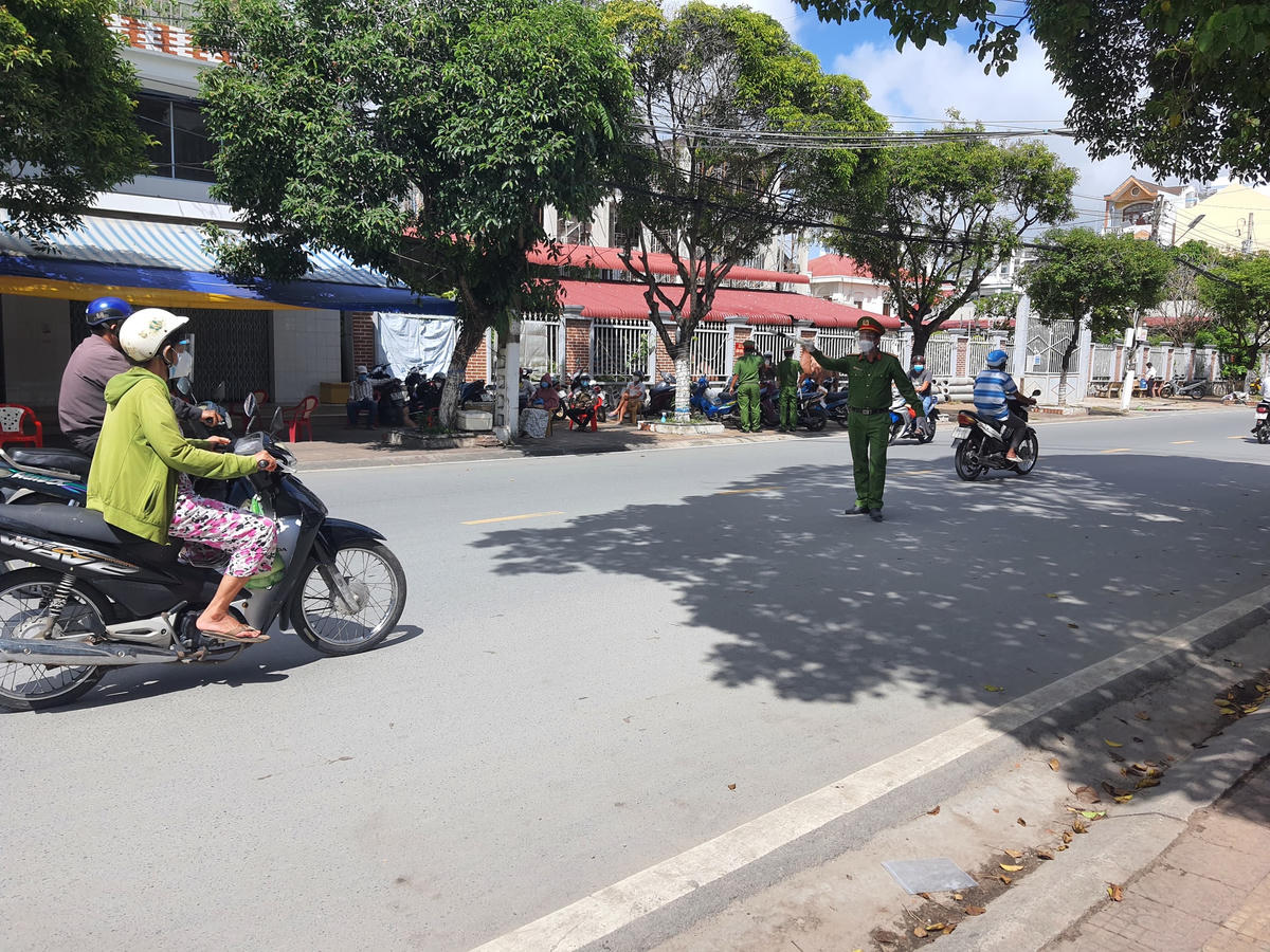 Lượng công an ra hiệu lệnh dừng xe để kiểm tra và mời vào lấy mẫu xét nghiệm Covid -19.