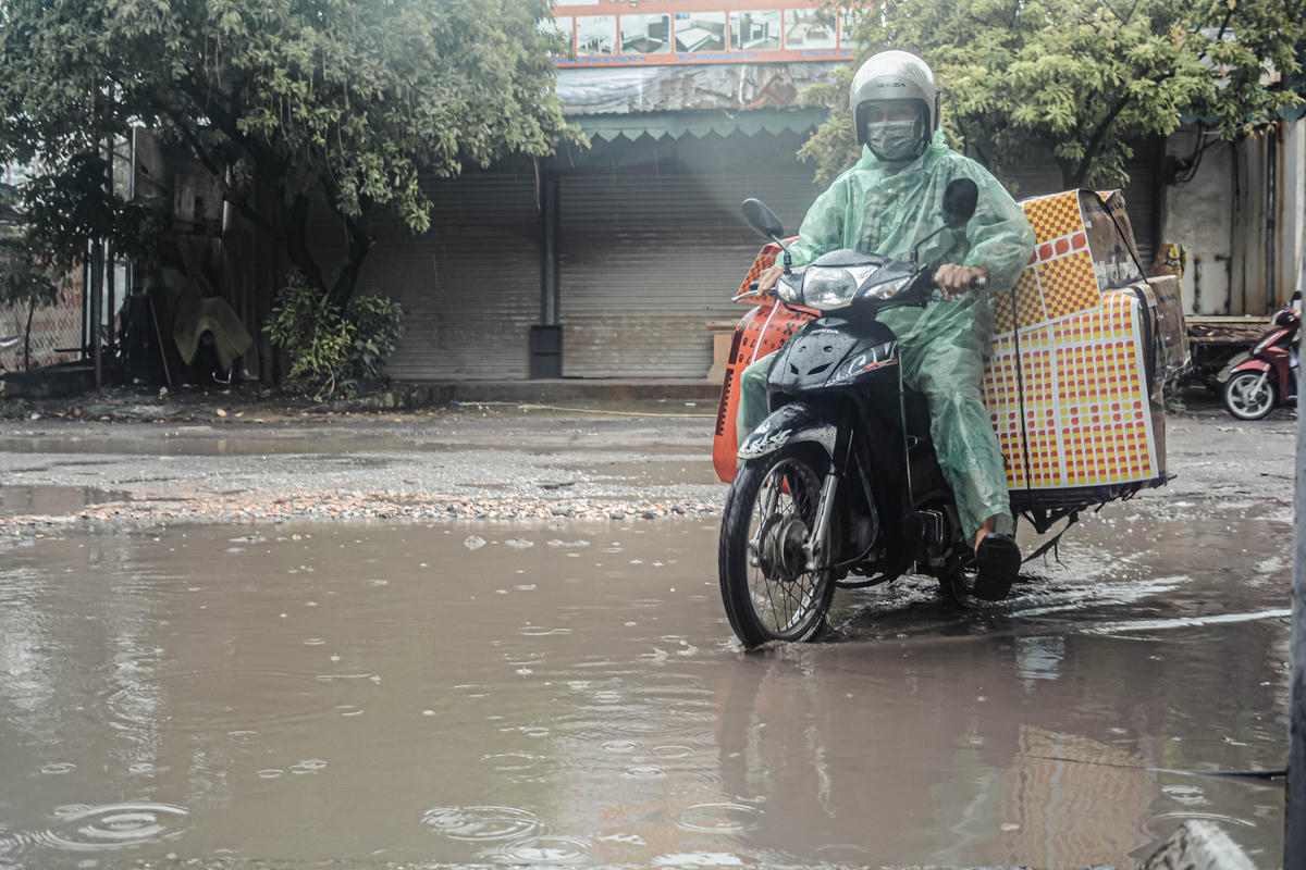 Người chở hàng nặng khó khăn khi phải lái xe giữa những vũng nước.