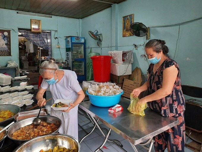 Mấy tháng nay, bà Đẹp, 57 tuổi (áo hoa) vốn làm nghề dọn việc nhà thuê thất nghiệp vì dịch nên đến phụ vợ chồng bà My một tay. Ảnh: Diệp Phan.