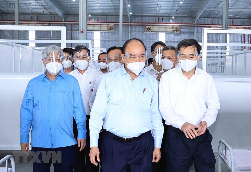 Chủ tịch nước Nguyễn Xuân Phúc, Chủ tịch UBTƯ MTTQ Việt Nam Đỗ Văn Chiến đến thăm Bệnh viện dã chiến tỉnh Bình Dương điều trị bệnh nhân Covid-19. (Ảnh: Thống Nhất/TTXVN).