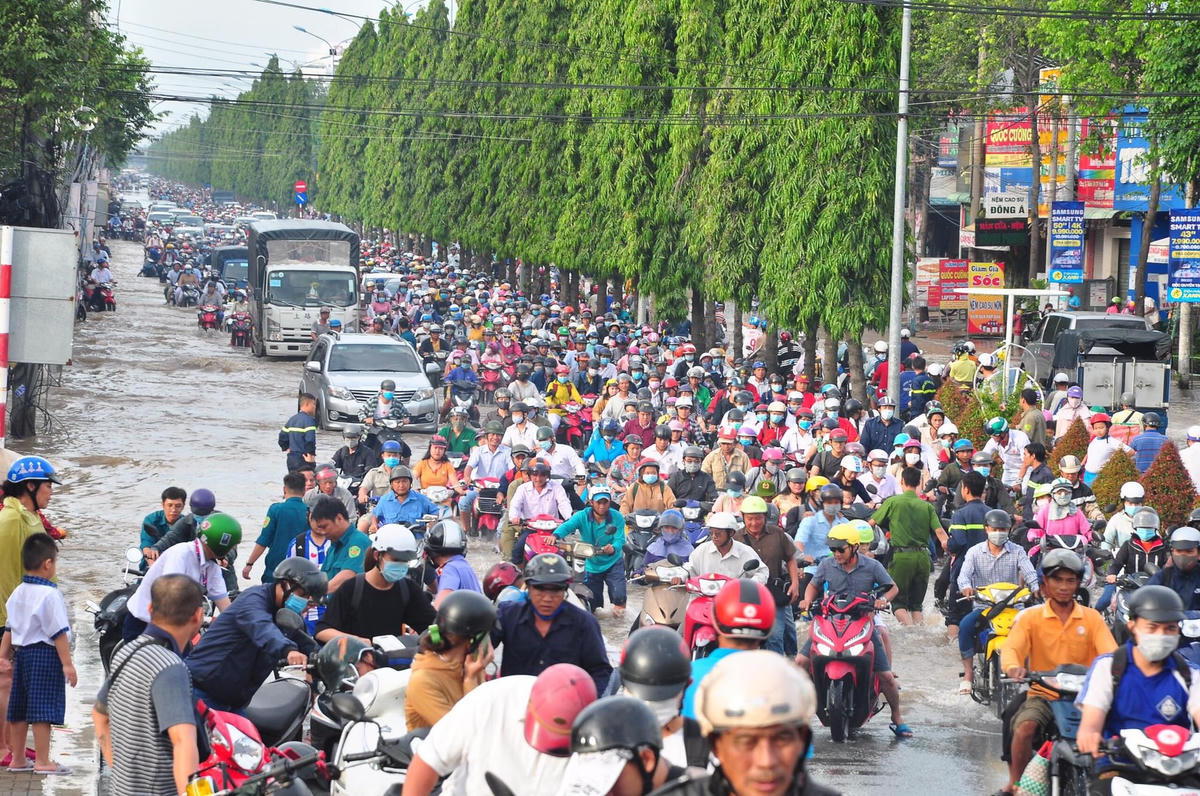 Triều cường khiến người dân di chuyển khó khăn.