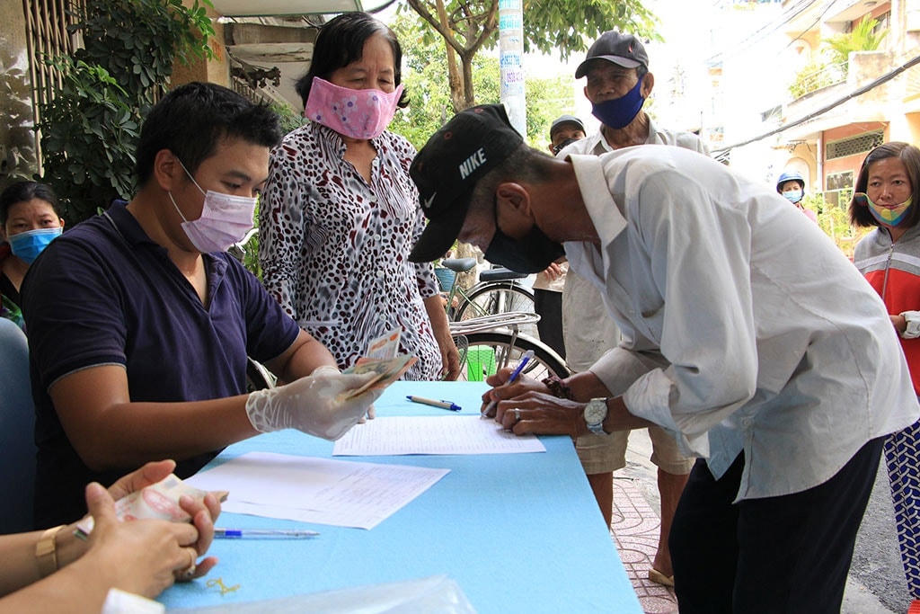 Người bán vé số ở TP HCM nhận tiền hỗ trợ từ Quỹ phòng, chống dịch Covid-19 do Ủy ban MTTQ TP HCM phân phối. Ảnh: Sỹ Đông.