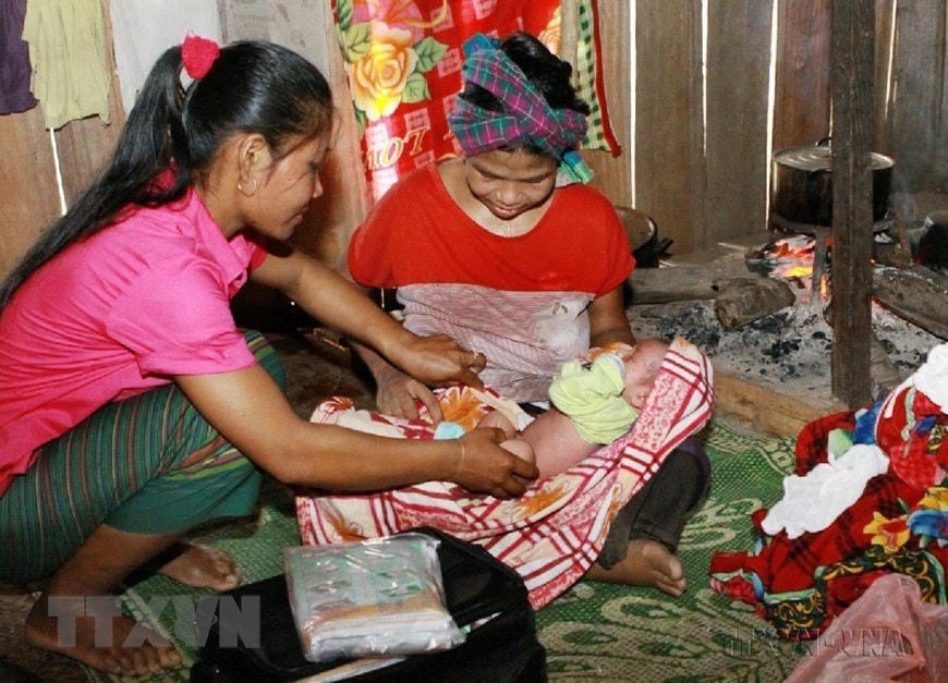 Cô đỡ thôn bản huyện Minh Hóa (Quảng Bình) chăm sóc sức khoẻ sinh sản cho đồng bào dân tộc. (Ảnh: Dương Ngọc/TTXVN)  