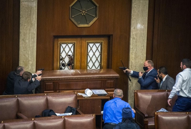 Lực lượng an ninh bảo vệ các nhà lập pháp từ bên trong tòa nhà. Ảnh: Washington Post.