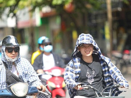 Thời tiết nắng nóng, tia UV ở mức cao, người dân cần trang bị tốt đồ bảo hộ khi ra đường để bảo vệ sức khỏe. (Ảnh: Thanh Tùng/TTXVN).