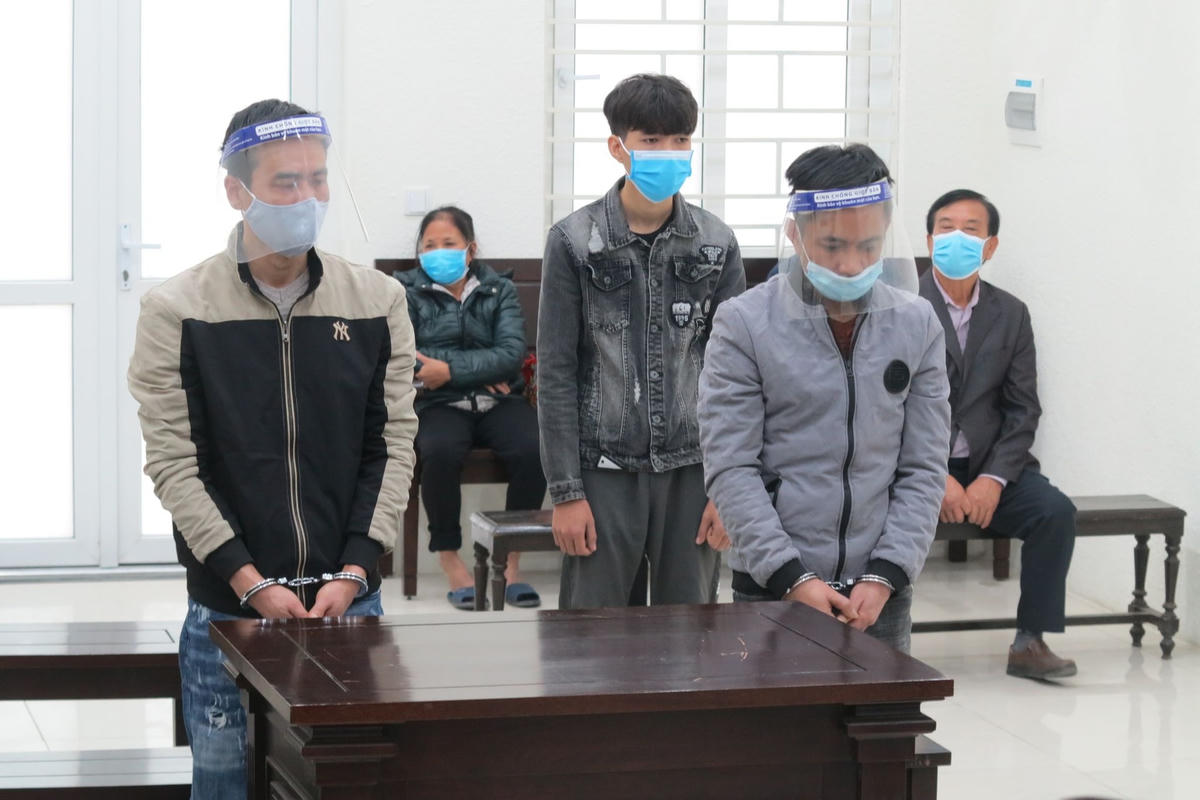 Các bị cáo Trung (bên trái) và Quân (bên phải) cùng Đức (phía sau) tại phiên tòa.
