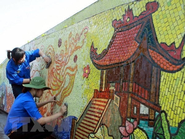 Các đoàn viên tham gia làm vệ sinh môi trường Con đường gốm sứ. (Ảnh: Đình Trân/TTXVN).