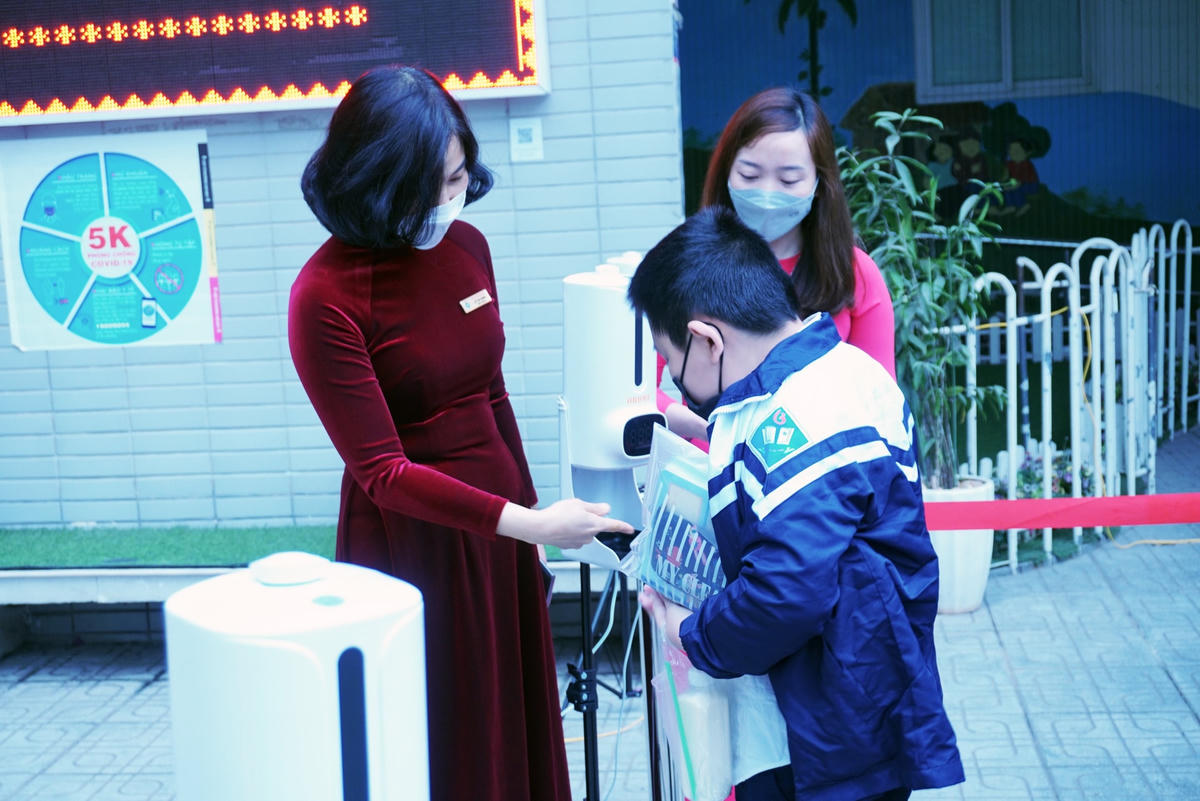 Các em được giáo viên hướng dẫn đi đúng hàng, sát khuẩn tay trước khi vào lớp.