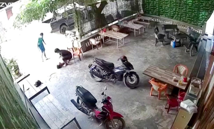 Ông Ng. bị đánh gục trên nền đất trước cổng nhà mình (Ảnh cắt từ Clip).