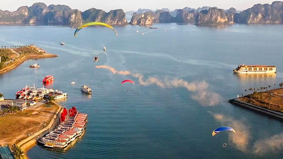 Trên mặt vịnh là những con tàu du lịch diễu hành qua lại làm nền cho sân khấu; phía trên bầu trời là màn trình diễn đầy ấn tượng, đặc sắc của trực thăng và dù lượn. Ảnh: Đỗ Phương.