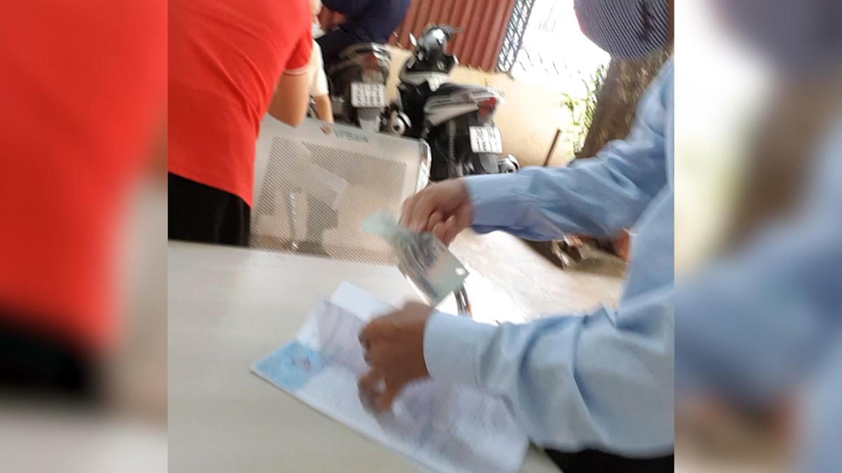 Hiện tượng “kẹp” tiền diễn ra công khai và dễ dàng ghi nhận tại các điểm đăng ký xe ô tô trên địa bàn Hà Nội.