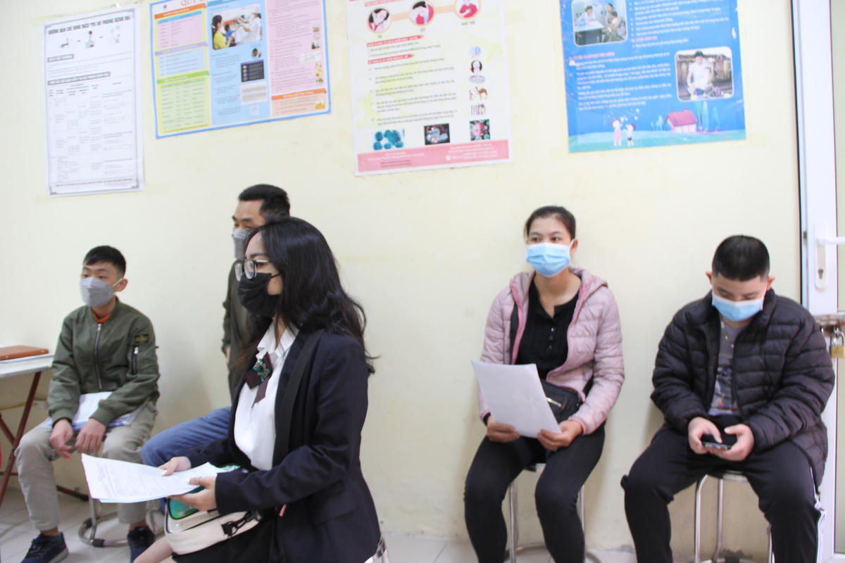 Các bậc phụ huynh chờ đợi đến lượt làm thủ tục tiêm vaccine cho các con.