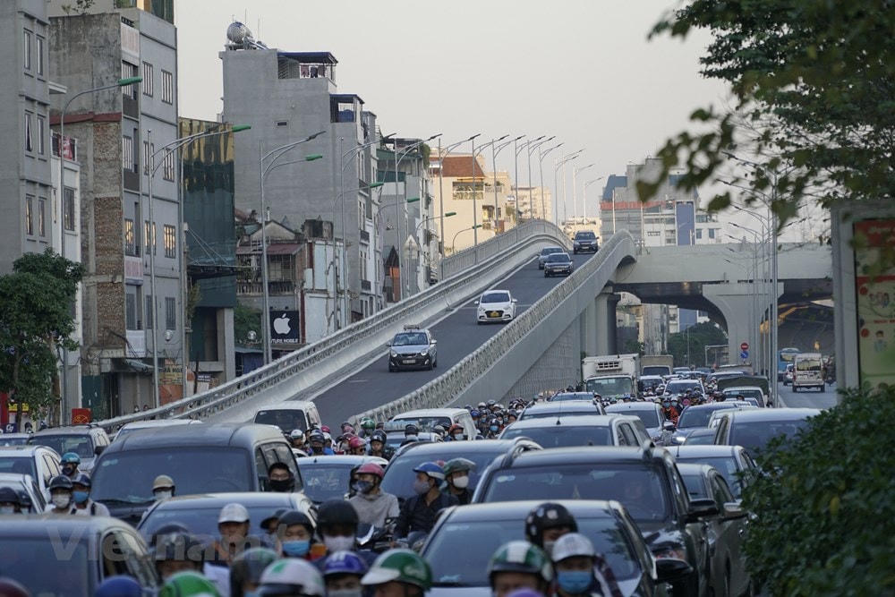 Hai điểm lên xuống cầu quá gần ngã tư nên không thể bố trí điểm quay đầu. Các phương tiện không có điểm quay đầu buộc phải đi vào ngã tư để quay ngược trở lại dẫn đến dồn ứ hàng trăm mét. (Ảnh: Minh Hiếu/Vietnam+).