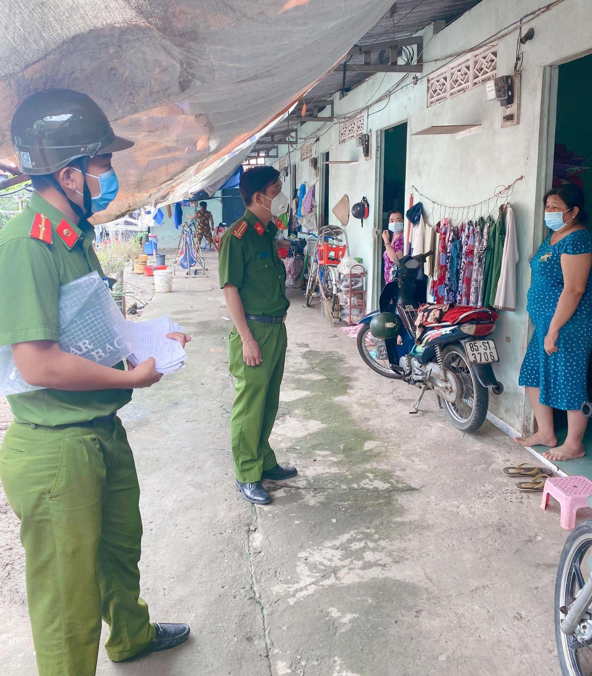 Trung tá Cao Văn Sơn, trưởng công an xã Hưng Long (giữa) đi khảo sát các hộ thuê trọ để lập danh sách nhận trợ cấp đợt 3.