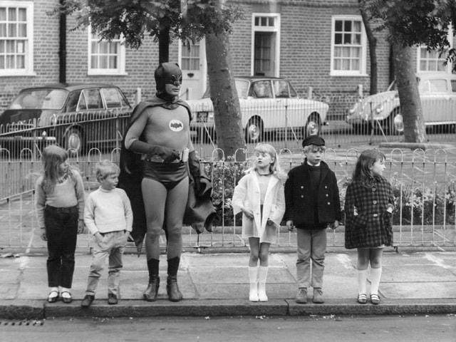 Nam diễn viên Adam West trong trang phục Người Dơi giúp trẻ nhỏ sang đường. Ảnh chụp hồi năm 1967. Lúc này, Adam West đang cùng một số trẻ nhỏ thực hiện đoạn clip hướng dẫn sang đường an toàn.  