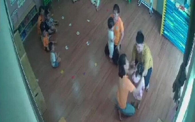 Bùi Mạnh Hùng (mặc áo vàng) đánh bé P.T.B.A. khiến cháu bé sưng tấy má phải, hoảng loạn tâm lý.