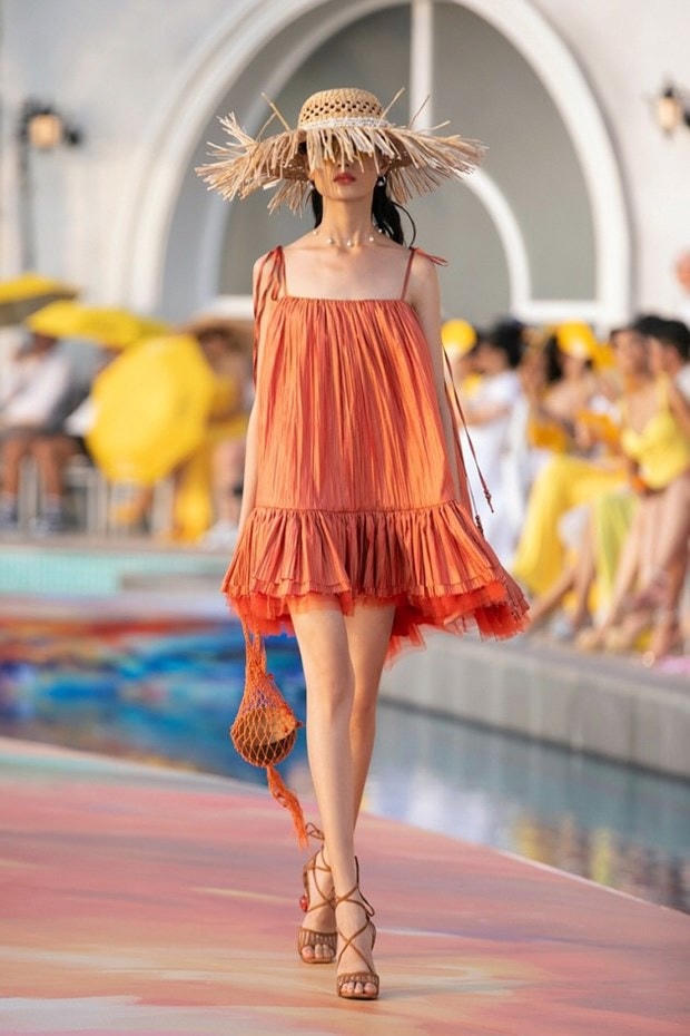 Thiết kế bay bổng và nữ tính của nhà thiết kế Lê Thanh Hòa được nhấn nhá bằng chiếc túi đan móc cùng màu váy.