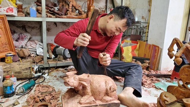 Anh Ngọc tỉ mẩn "thổi hồn" vào chú trâu anh tâm đắc.  