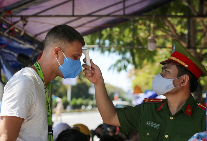 Công an tỉnh Quảng Nam kiểm tra thân nhiệt một người nước ngoài từ Đà Nẵng đi qua chốt kiểm dịch số 1, đường ĐT 603 B, phường Điện Ngọc, thị xã Điện Bàn, ngày 29/7/2020. Ảnh: Đắc Thành.