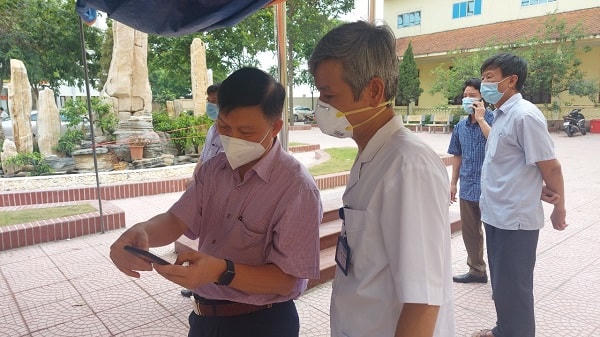 PGS.TS Trần Quý Tường (bên trái) hướng dẫn cán bộ y tế cơ sở thực hiện cập nhật dữ liệu trên điện thoại.