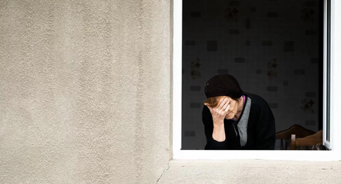 Một phụ nữ buồn bã, thất vọng bên ô cửa sổ sau trận pháo kích.  