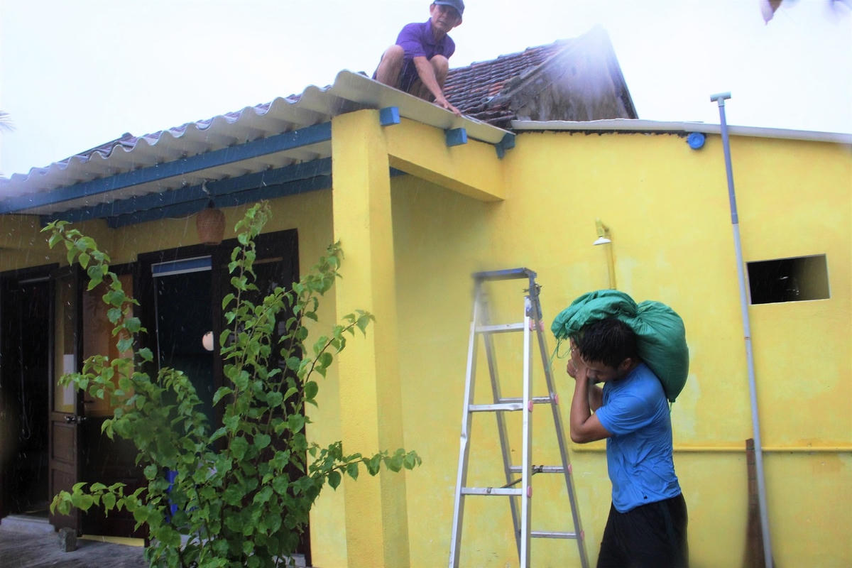 Người dân vận chuyển bao cát để chằng chống mái nhà.
