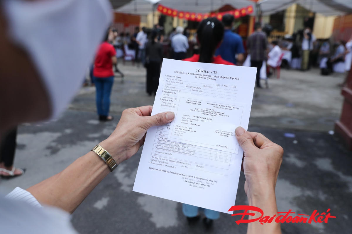 Mỗi cử tri sẽ có thẻ cử tri và tờ khai y tế. Cử tri sẽ phải điển đầy đủ thông tin vào tờ khai y tế nhằm đảm bảo an toàn trong công tác phòng, chống dịch Covid-19. Ảnh: Quang Vinh. 