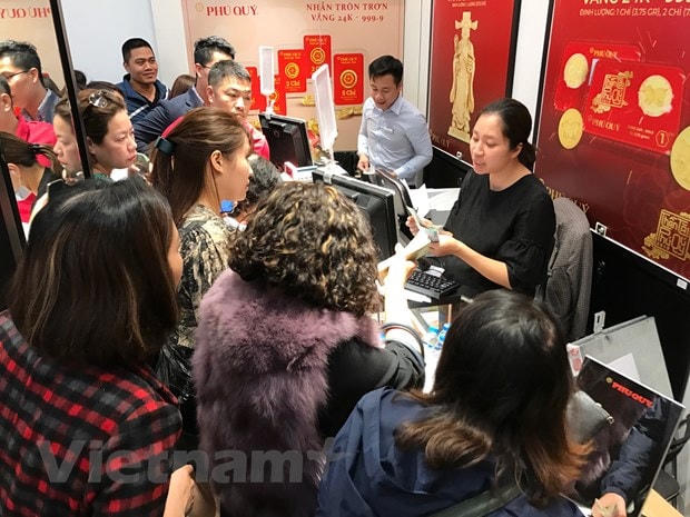 Khách hàng giao dịch vàng miếng. (Ảnh: Vietnamplus).