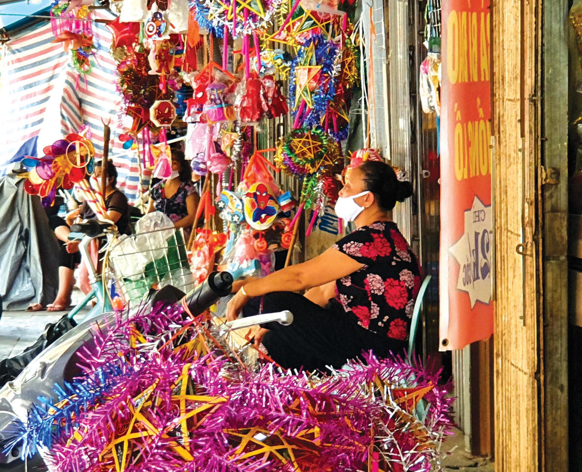 Một chủ cửa hàng ngồi lặng lẽ bên gian hàng vắng khách.