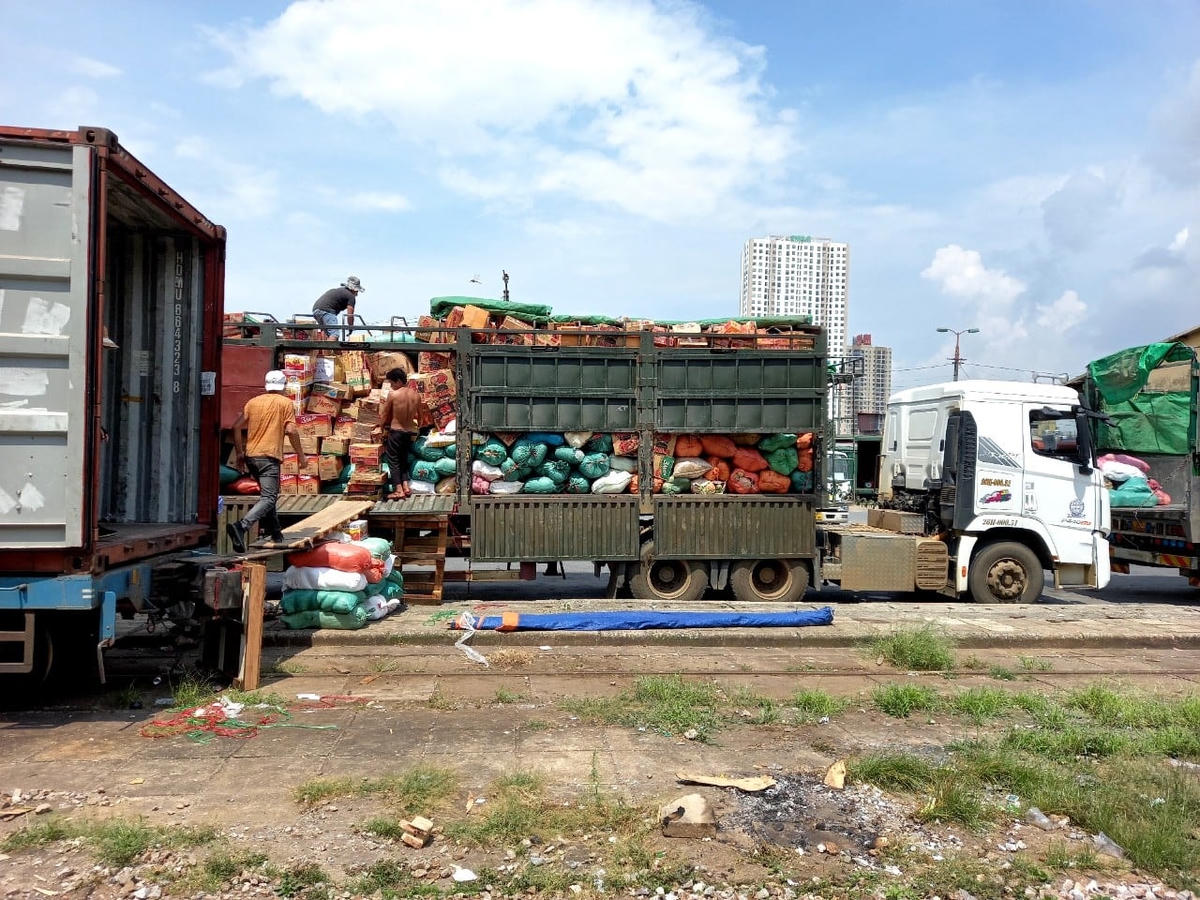 Hơn 100 tấn nông sản của Sơn La được bốc xếp từ các xe hàng lên tàu.
