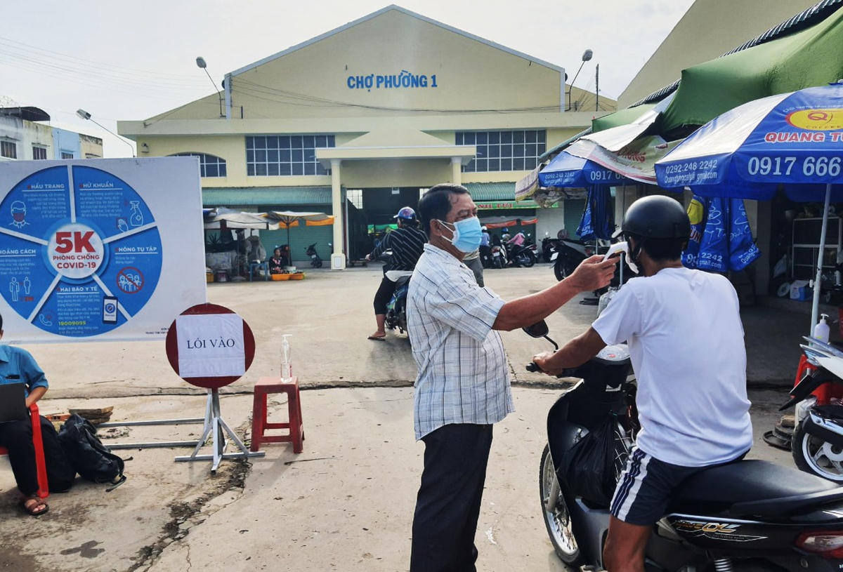 Kiểm soát, kiểm tra thân nhiệt chặt người ra và vào khu vực chợ.