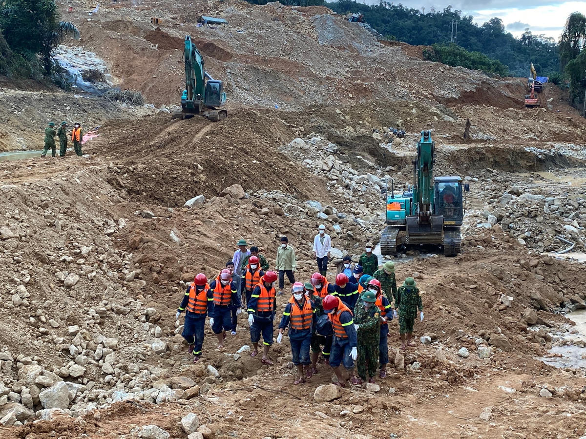 Các lực lượng chức năng đưa thi thể nạn nhân ra khỏi khu vực tìm kiếm.