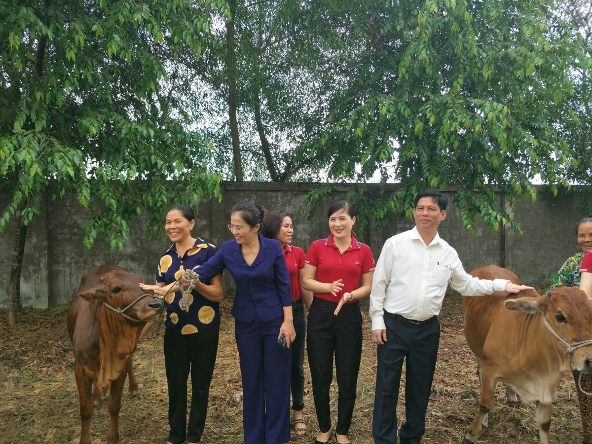Bà Võ Thị Minh Sinh (thứ hai từ trái sang) trao bò cho hộ nghèo tại xã Nghi Thạch, huyện Nghi Lộc, Nghệ An. Ảnh: Điền Bắc.