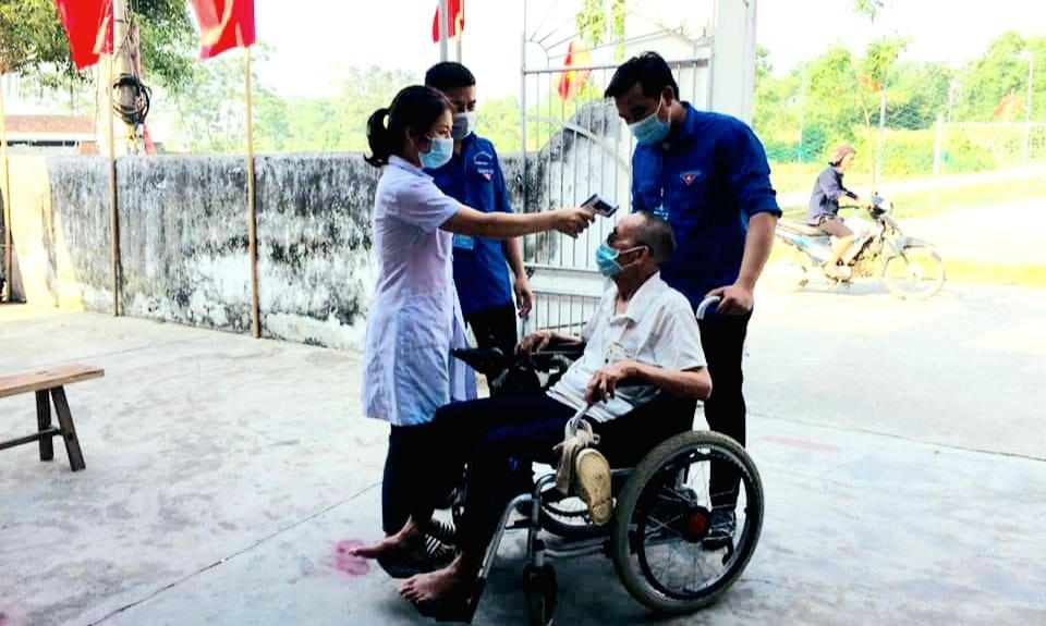 Bác Nguyễn Công Chơng (92 tuổi) trú tại xóm Lộc Xuân, xã Đồng Văn, huyện Thanh Chương đến điểm bỏ phiếu trên chiếc xe lăn (Ảnh: Phạm Tùng).