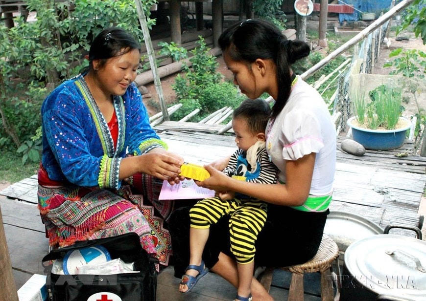 Cô đỡ thôn bản chăm sóc sức khoẻ bà mẹ, trẻ em tại huyện Mường Nhé (Điện Biên). (Ảnh: Dương Ngọc/TTXVN)  