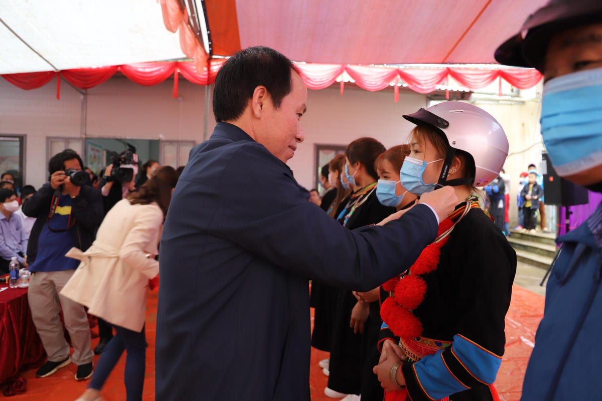 Phó Chủ tịch - Tổng Thư ký Lê Tiến Châu trao mũ bảo hiểm cho các hộ gia đình tại thôn Bản Chằng.