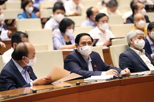Chủ tịch nước Nguyễn Xuân Phúc và Thủ tướng Phạm Minh Chính cùng các đại biểu Quốc hội tham dự phiên họp ngày 25/7. Ảnh: Dương Giang/TTXVN.  