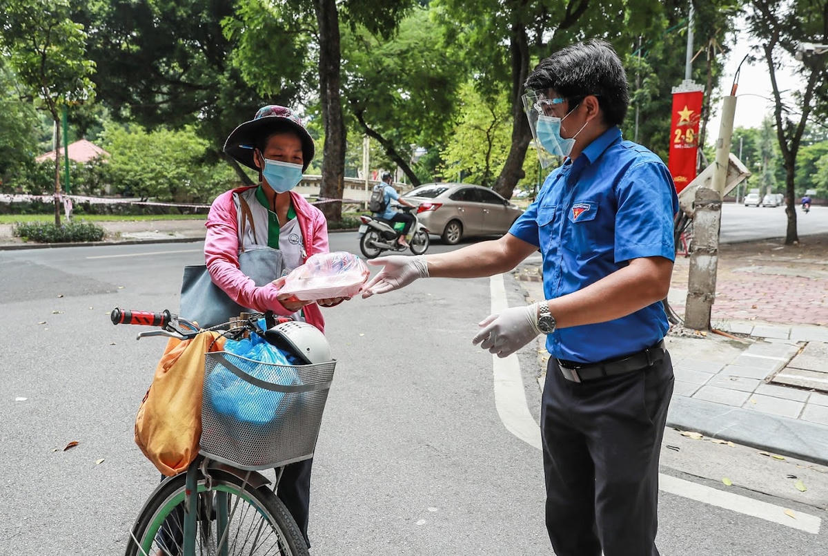 Người dân xúc động nhận suất cơm từ nhân viên Báo Đại Đoàn Kết.