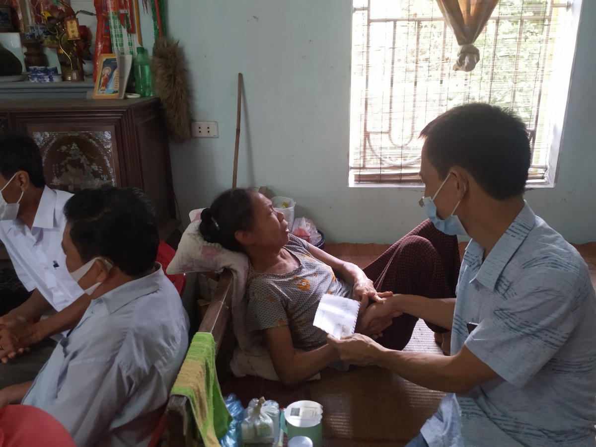 Phóng viên Báo Đại Đoàn Kết trao tiền hỗ trợ của cộng đồng tới bà Thêm.