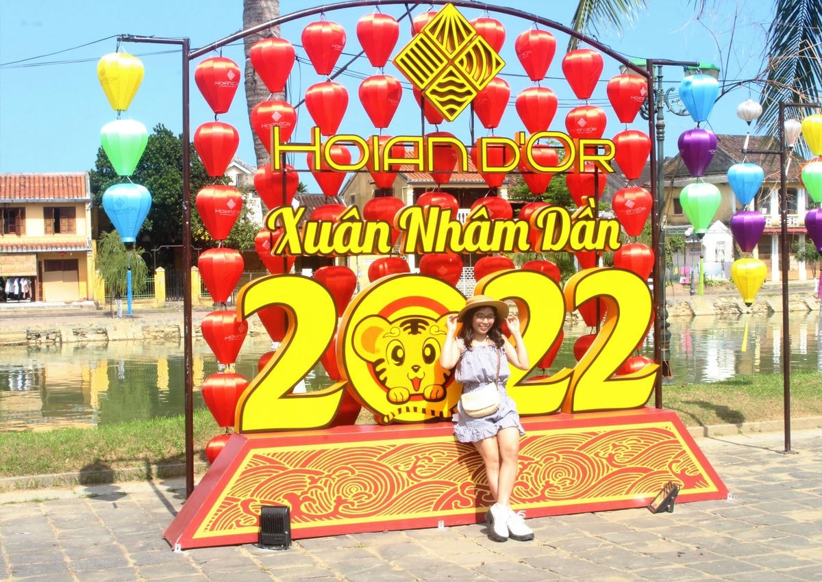 Các bạn trẻ chụp ảnh lưu niệm ở bên bờ sông Hoài, TP Hội An.